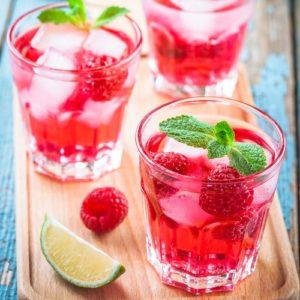 Raspberry mojito in a glass with mint and lime